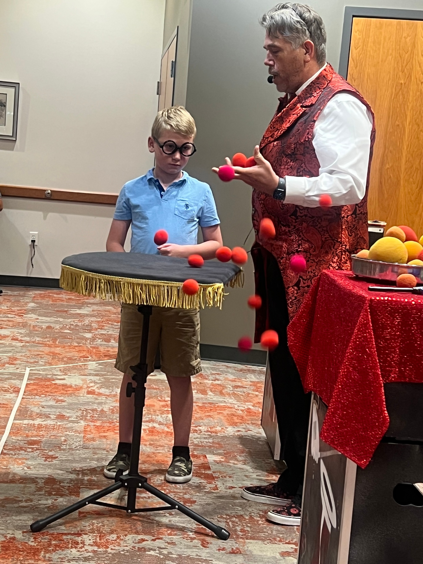 Tres performing the sponge ball routine with a young volunteer